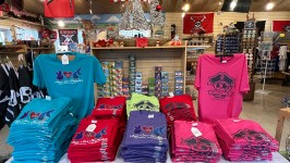 Colorful t-shirts with pirate-themed designs displayed on a store table.