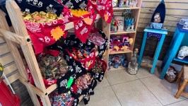 Store display with assorted candies in baskets and wooden shelves with packaged snacks.