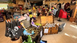 Store interior with pirate-themed decor, flags, stuffed animals, and clothing displays.