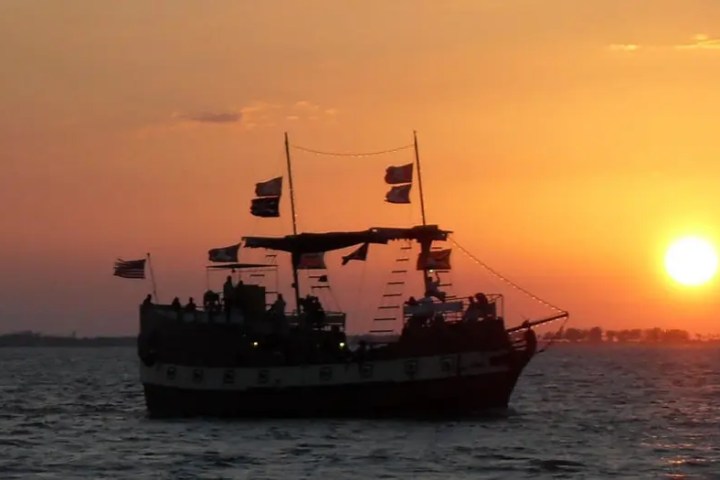 Silhouette of a ship at sunset on a calm sea.